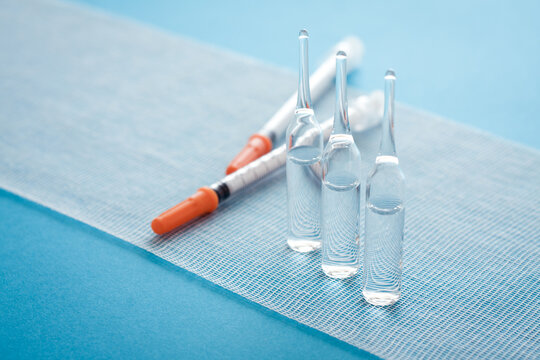 Ampules and syringes on steile bandage surface. Close up image of medical supplies.