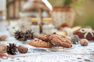 
The picnic is decorated in a rustic style. Delicious homemade cookies on a background of decorative items made of natural materials on a lace tablecloth