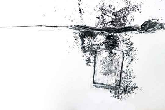 perfume bottle falls into water on a white background