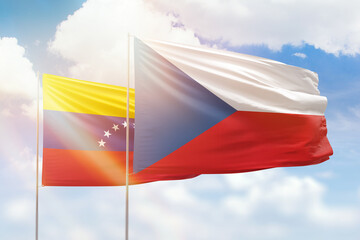 Sunny blue sky and flags of czechia and venezuela