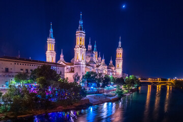 Basilica del Pilar de Zaragoza, at night, with the Ebro River and the Santiago Bridge in the background