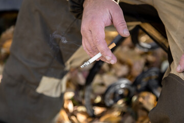 Bad habit. A smoking cigarette in a man's hand. The concept of the dangers of smoking and tobacco consumption with copy space for text