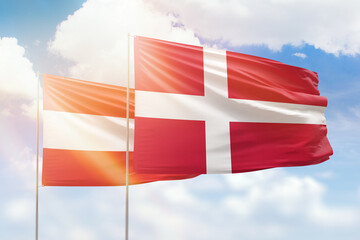 Sunny blue sky and flags of denmark and austria