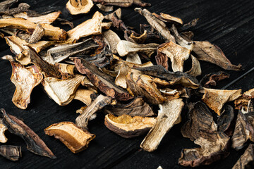 Wild organic dried porcini mushroom, on black wooden table background