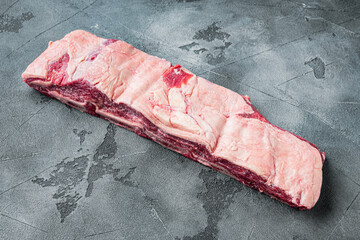 Raw meat ribs, on gray stone background, with copy space for text