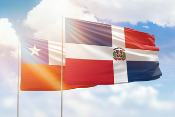 Sunny blue sky and flags of dominican republic and chile