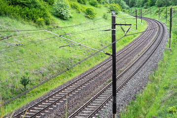 The electrified railway line in a beautiful green valley.