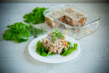 jellied meat with greens and vegetables in a plate