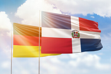 Sunny blue sky and flags of dominican republic and germany