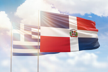 Sunny blue sky and flags of dominican republic and greece