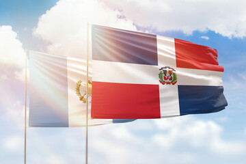 Sunny blue sky and flags of dominican republic and guatemala