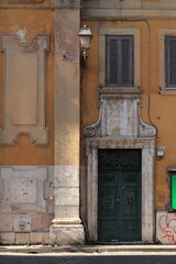 Trastevere Old Building Facade Close Up with Green Wooden Door and Sculpted Stone Frame in Rome, Italy