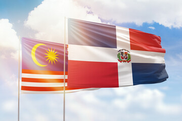 Sunny blue sky and flags of dominican republic and malaysia