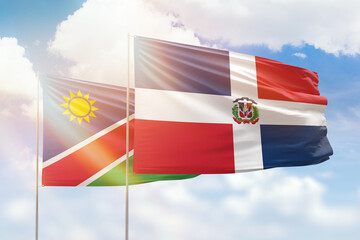 Sunny blue sky and flags of dominican republic and namibia