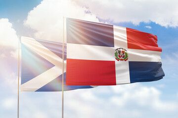 Sunny blue sky and flags of dominican republic and scotland