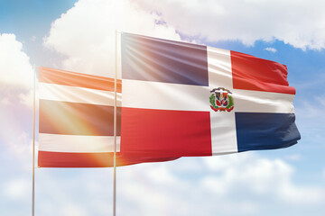 Sunny blue sky and flags of dominican republic and thailand