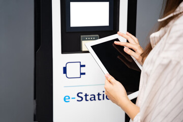 Young Asian or Caucasian woman wearing shirt holding and using white tablet, connecting to...
