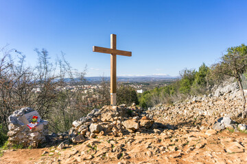 A landscape photo of the wooden cross at the apparition hill in Medjugorje, Bosnia and Herzegovina.