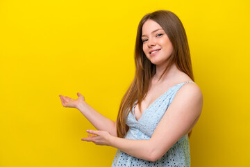 Young caucasian woman isolated on yellow background extending hands to the side for inviting to come