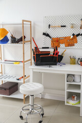 Workplace, shelf unit and different modern tools in workshop interior