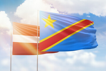 Sunny blue sky and flags of dr congo and latvia