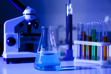 Conical flask with liquid on table in medical laboratory