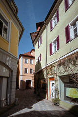 Fototapeta na wymiar View in the old town of Ansbach. A narrow street with buildings painted in subtle colours. Bavaria Region Middle Franconia, Germany