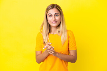 Blonde Uruguayan girl isolated on yellow background laughing
