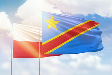 Sunny blue sky and flags of dr congo and poland