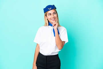 Airplane stewardess Uruguayan woman isolated on blue background thinking an idea while looking up