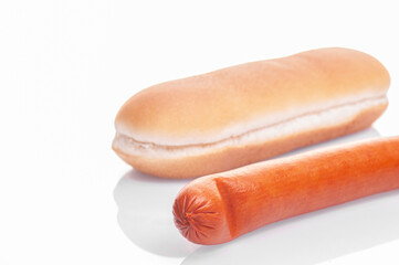 hot dog bun and sausage lie on a white background