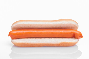 in a bun for a hot dog on a white background lies a sausage