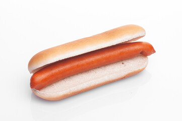 in a bun for a hot dog diagonally on a white background lies a sausage