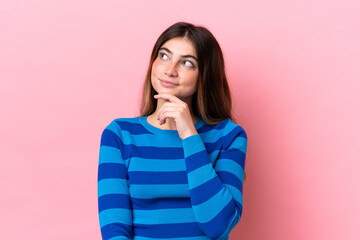 Young caucasian woman isolated on pink background thinking an idea while looking up