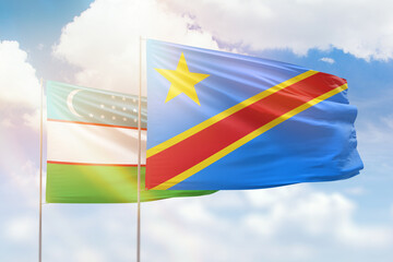 Sunny blue sky and flags of dr congo and uzbekistan