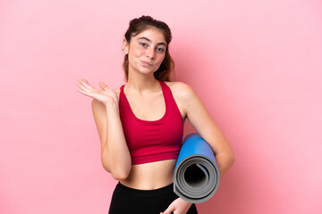 Young sport woman going to yoga classes while holding a mat having doubts while raising hands