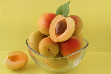 Apricots in a bowl isolated on yellow.