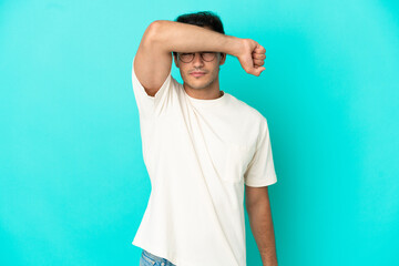 Caucasian handsome man over isolated blue background covering eyes by hands