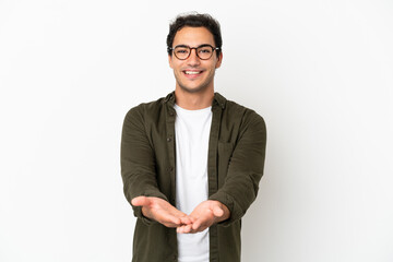 Caucasian handsome man over isolated white background holding copyspace imaginary on the palm to insert an ad
