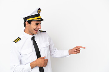 Airplane pilot over isolated white background pointing finger to the side and presenting a product