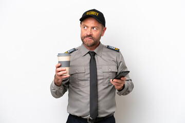 Middle age security man isolated on white background holding coffee to take away and a mobile while thinking something