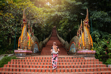 Joven mujer adentrándose a templo budista Doi Suthep, en Chiang Mai, Tailandia