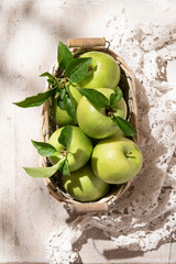 Granny Smith apples in basket. Fresh green fruit on rustic white background