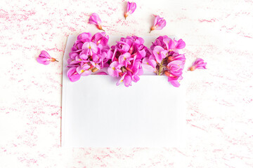 White envelope with acacia flowers