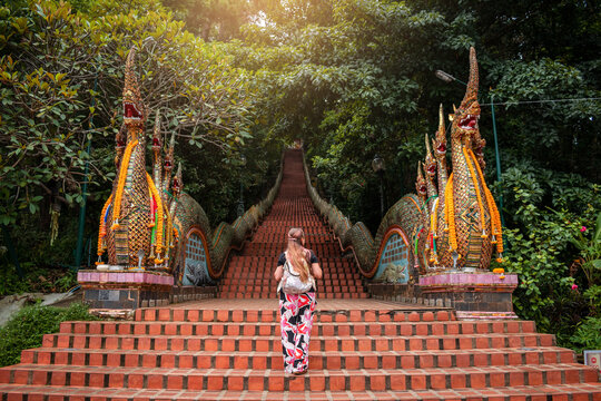 Joven mujer adentr&aacute;ndose a templo budista Doi Suthep, en Chiang Mai, Tailandia