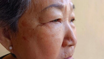 Obraz premium An old woman has wrinkles on her face.