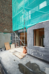 Fototapeta na wymiar Facade insulation with protected scaffolding