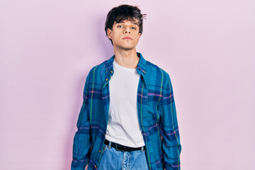 Handsome hipster young man wearing casual white t shirt and vintage shirt relaxed with serious expression on face. simple and natural looking at the camera.