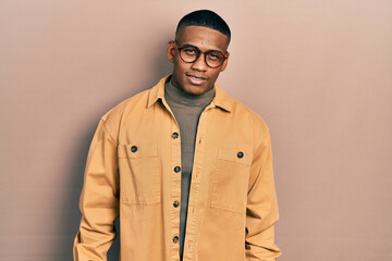 Young black man wearing casual clothes and glasses looking positive and happy standing and smiling with a confident smile showing teeth