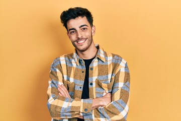 Young hispanic man wearing casual clothes happy face smiling with crossed arms looking at the camera. positive person.